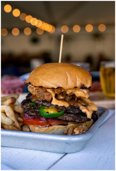 Close-up of a gourmet cheeseburger with fries, tom