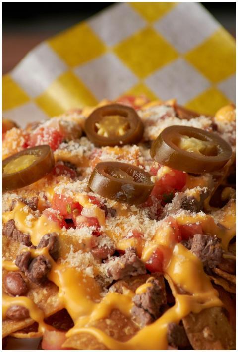 Tasty nachos topped with melted cheese, jalapeños,