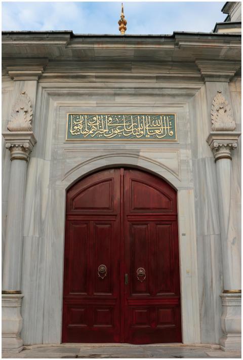 Beautiful mosque entrance with ornate red doors an