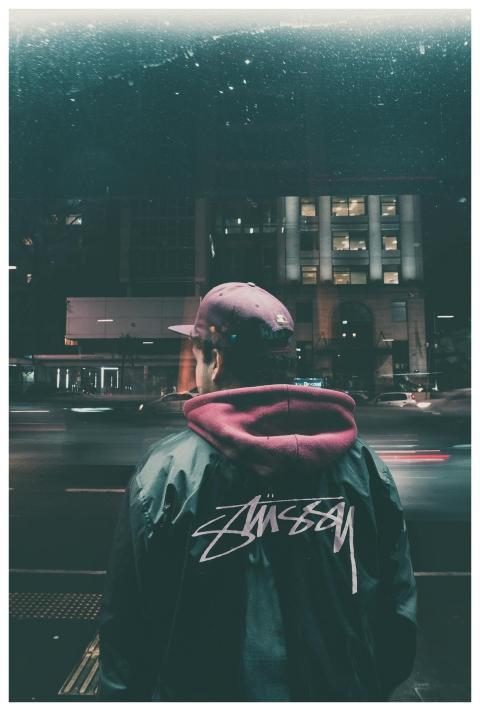 Man standing in city at night wearing a stylish ja