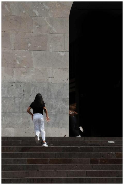 A woman in Brescia, Italy, walks up grand city sta