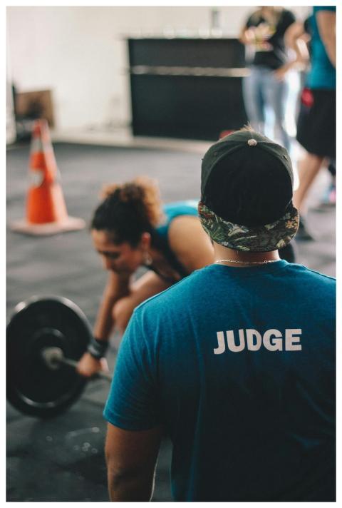 A CrossFit judge keeps an eye on a female athlete