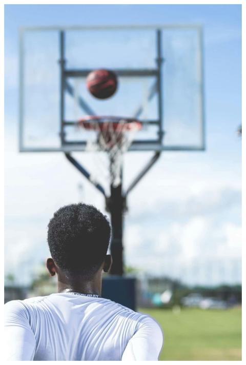 A young athlete focuses on shooting a basketball,