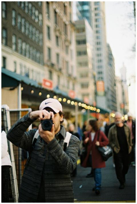 A photographer takes pictures in a bustling urban