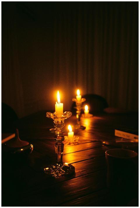 A warmly illuminated dining room set with lit cand