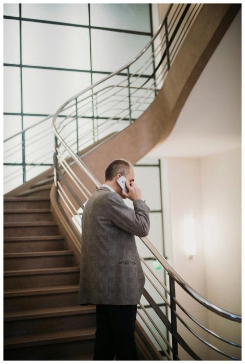A businessman in a suit talks on his smartphone by