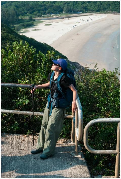 A hiker rests while enjoying a scenic view of a be