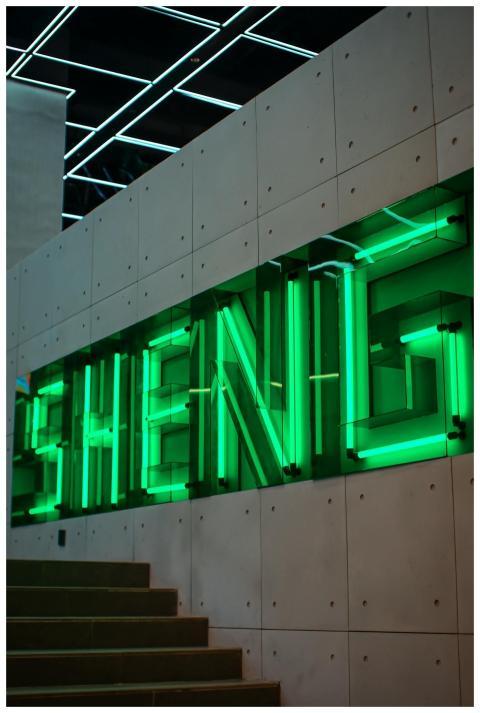 Neon green 'SHENIG' sign in modern architectural d