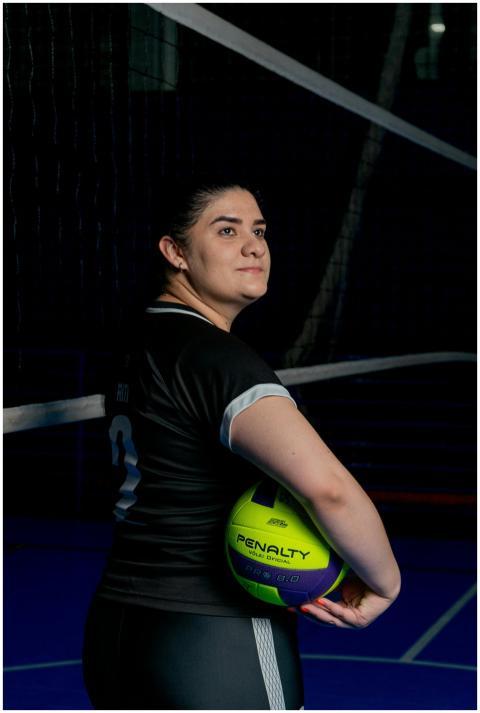 A focused volleyball player holding a ball indoors