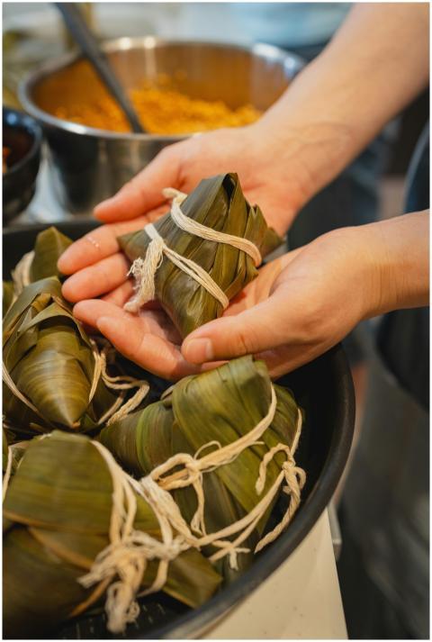 Close-up of hands crafting rice dumplings wrapped