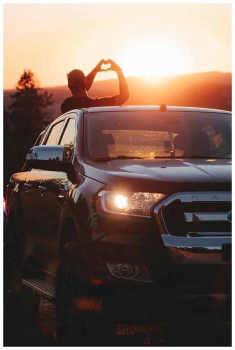 Silhouette of a person making a heart gesture duri