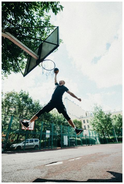 A skilled player performs a basketball dunk on an