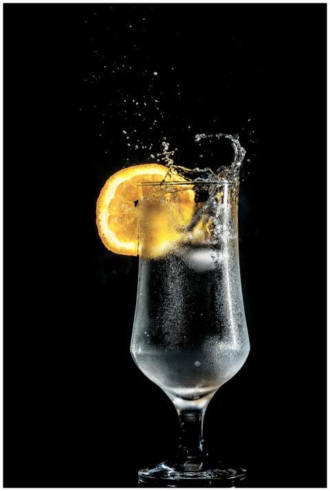 Dazzling cold cocktail with citrus slice splash, s