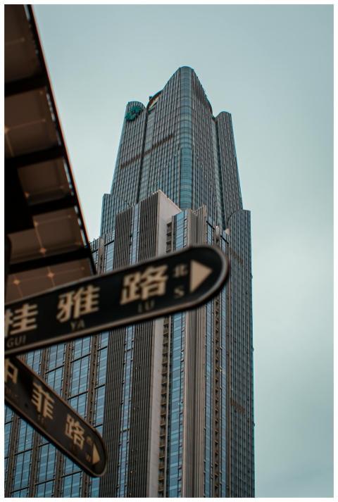 Tall skyscraper with street signs in Chinese, city
