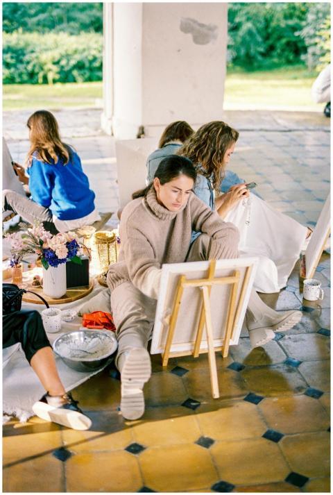 A group of women engaged in painting and creating