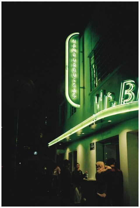 Vivid neon lights illuminate a bustling street in