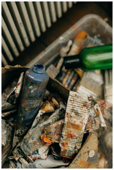 A creative mess of used paint tubes and plastic bo