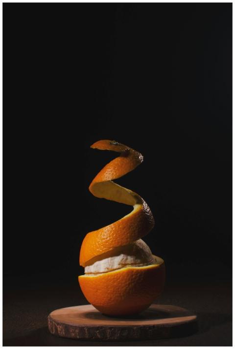 A creatively peeled orange with spiral skin on a w