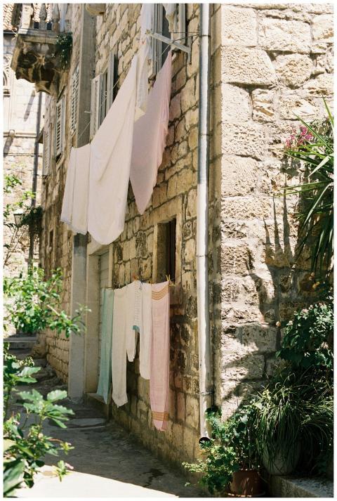 Rustic stone building with clothesline and greener