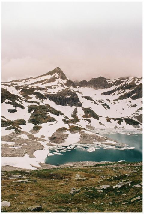 A stunning snowy mountain scene with a turquoise l