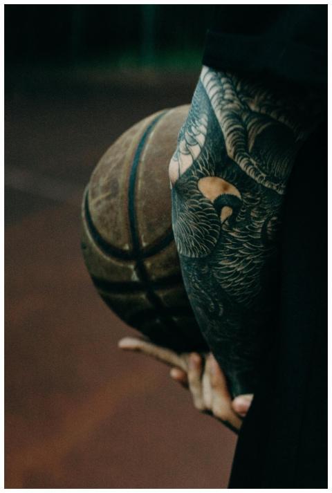 Close-up of a tattooed arm holding a basketball, s