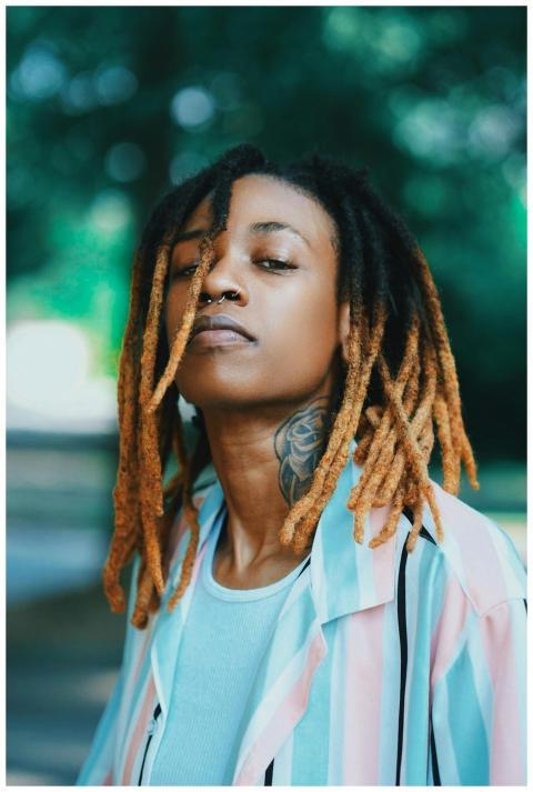 Outdoor portrait of a woman with dreadlocks and ta