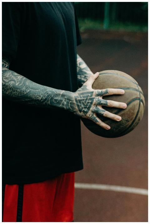 Close-up of a tattooed athlete holding a basketbal