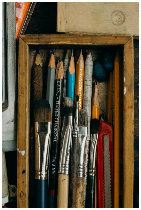 Close-up of assorted art supplies in a vintage woo