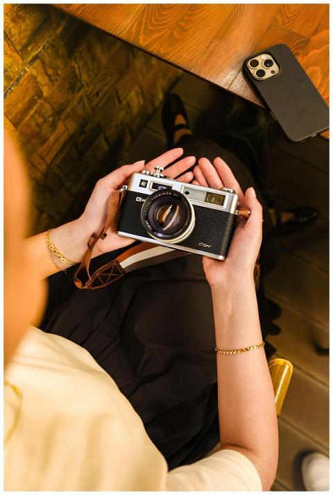 Person holding vintage camera, capturing creative