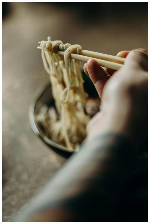 Appetizing close-up image of noodles being lifted