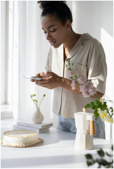 Woman capturing a stylish coffee setup in a sunlit