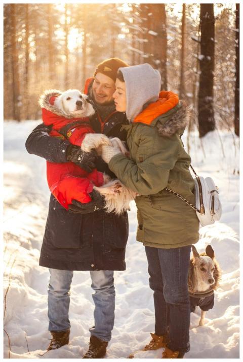 A couple in winter clothing enjoys a snowy forest