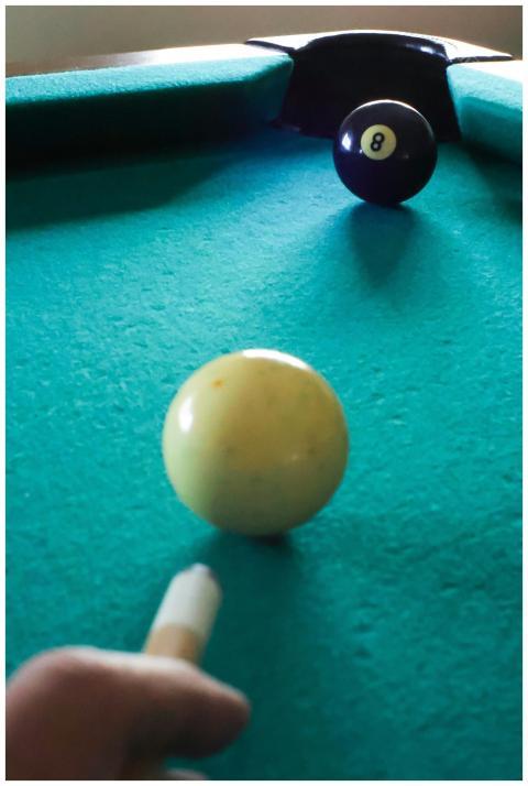 Focused view of player aiming at eight ball on a p