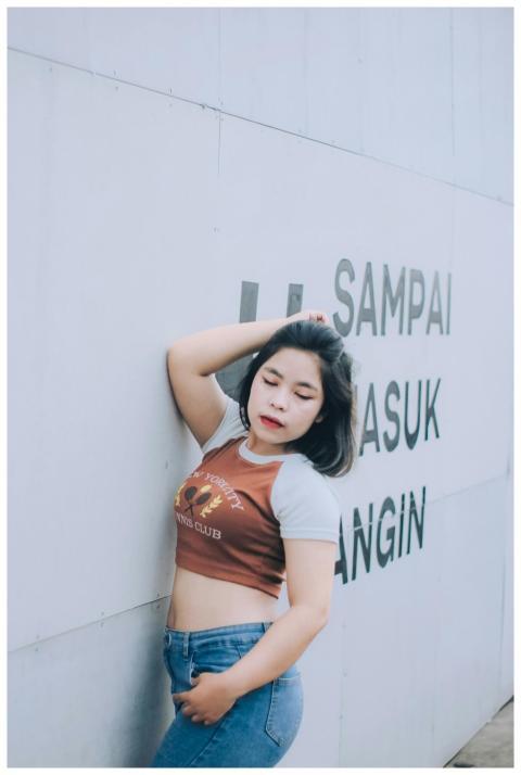 Stylish Asian woman posing in denim and a crop top
