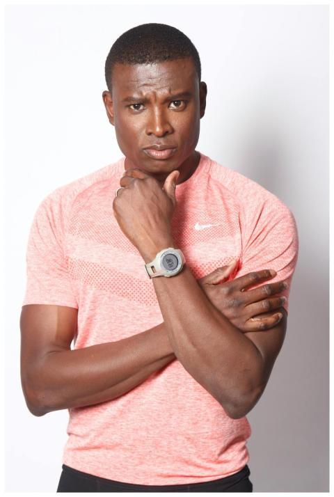 Athletic black man in a pink sports shirt poses wi