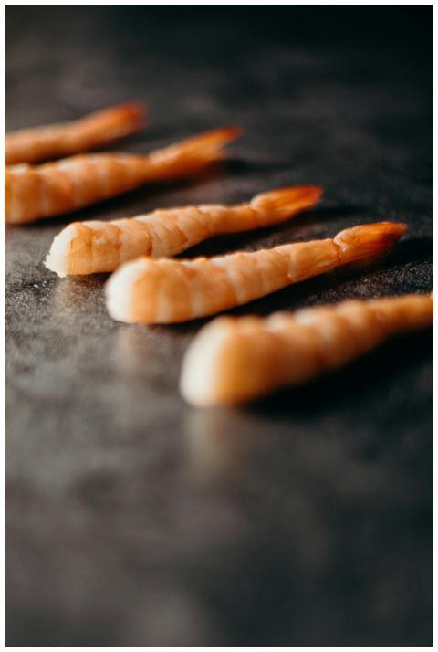 Detailed image of raw shrimp tails on a dark textu