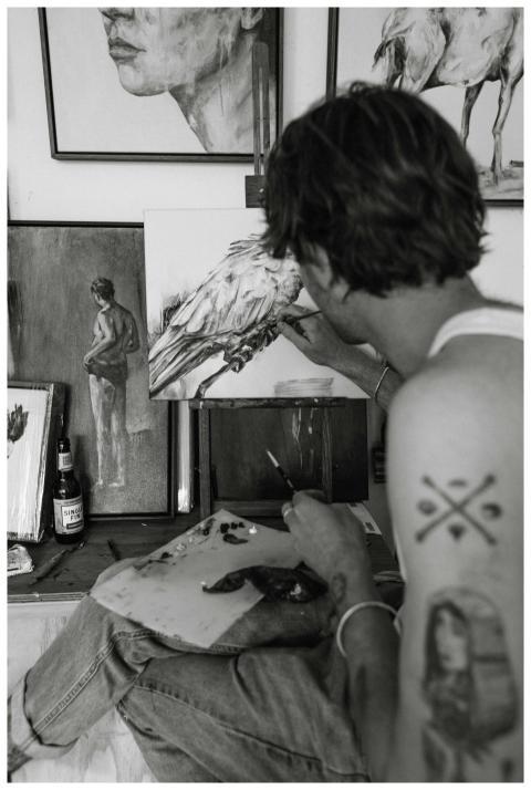 A male artist painting in his studio captured in a