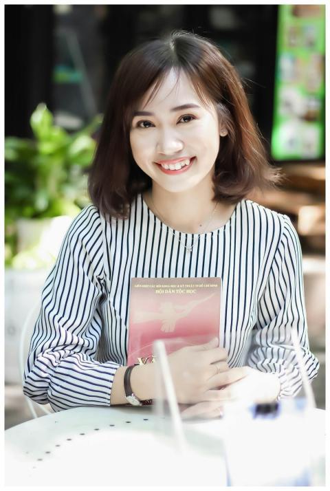 Young woman in striped blouse smiling and holding