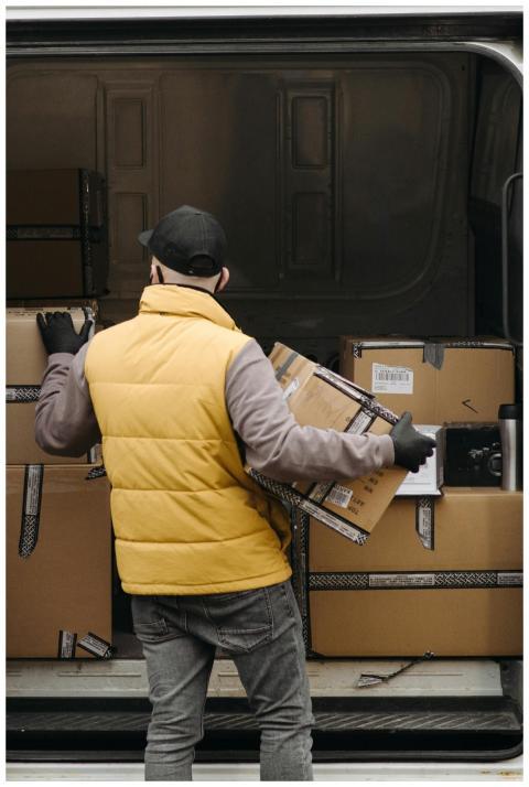 Deliveryman organizing packages into a van for dis