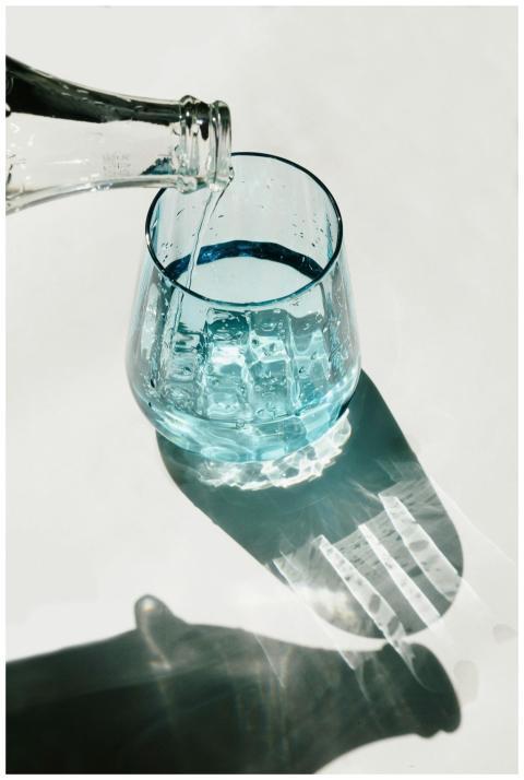 Closeup of water being poured into a glass, with a