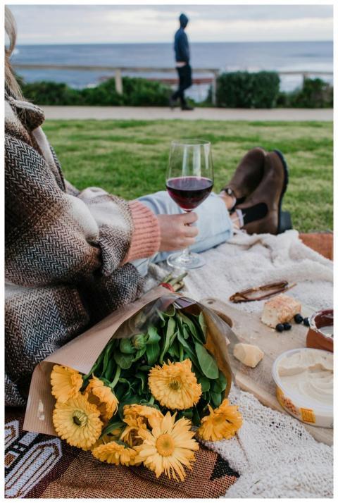 A relaxing picnic by the sea with wine, cheese, an