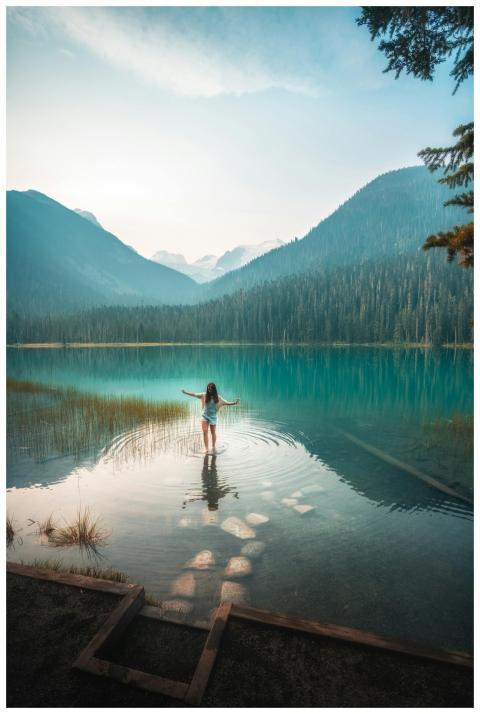 A woman stands peacefully in a clear Canadian moun