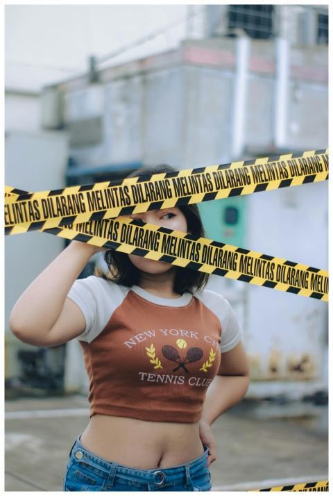 Woman standing behind yellow caution tape in an ur