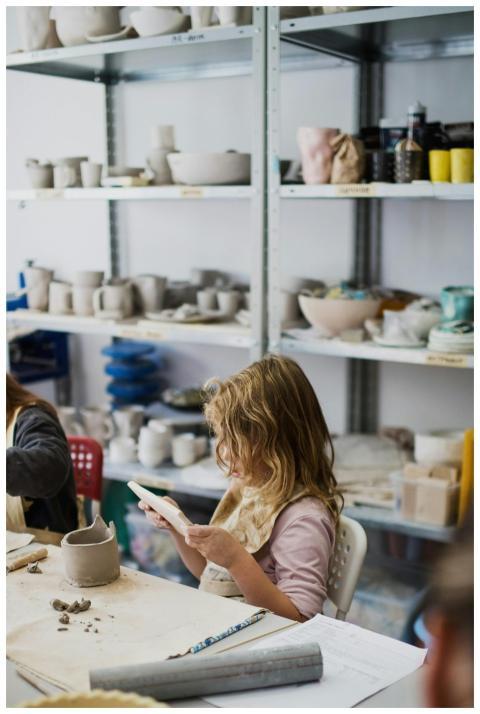 Young girl focused on crafting clay in a vibrant p