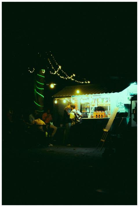 Illuminated street food stand at night with people