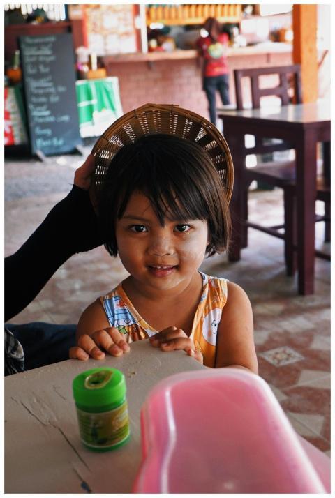 Adorable child with basket hat in a cozy restauran