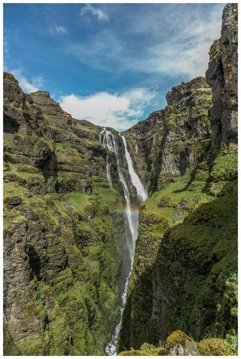 Spectacular waterfall cascading between lush green