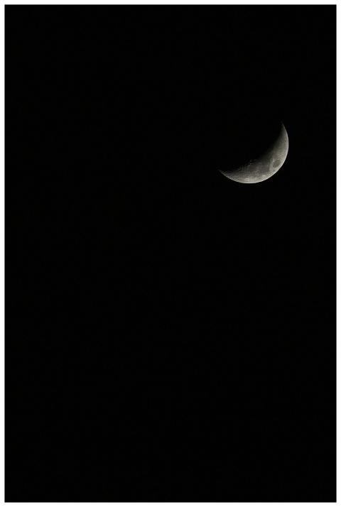 Stunning crescent moon set against a vast, dark ni