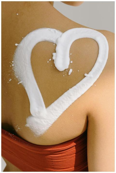 Close-up of a woman's shoulder with sunscreen in a