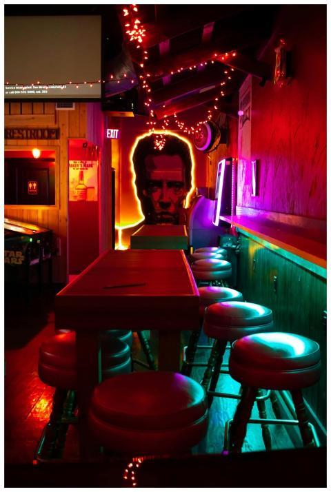 Vibrant neon-lit bar with artistic decor and empty